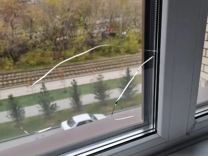Треснувший стеклопакет в окне ПВХ рядом с рамой